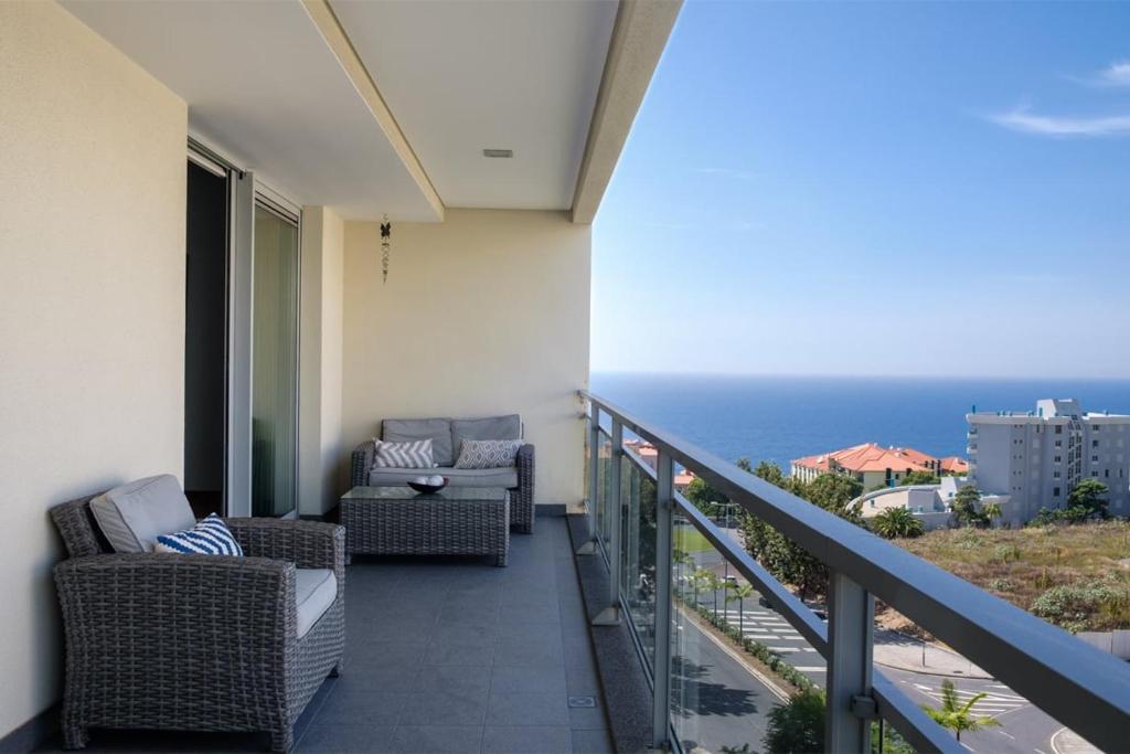 een balkon met 2 stoelen en uitzicht op de oceaan bij GuestReady - Scenic Retreat with Seaview in Funchal