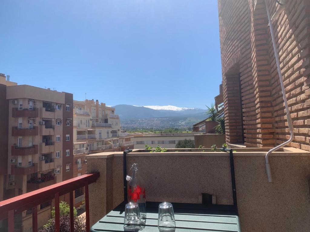 a table on a balcony with a view of a city at Apartamento, Piccolo Mare, junto centro, vistas Sierra Nevada in Granada