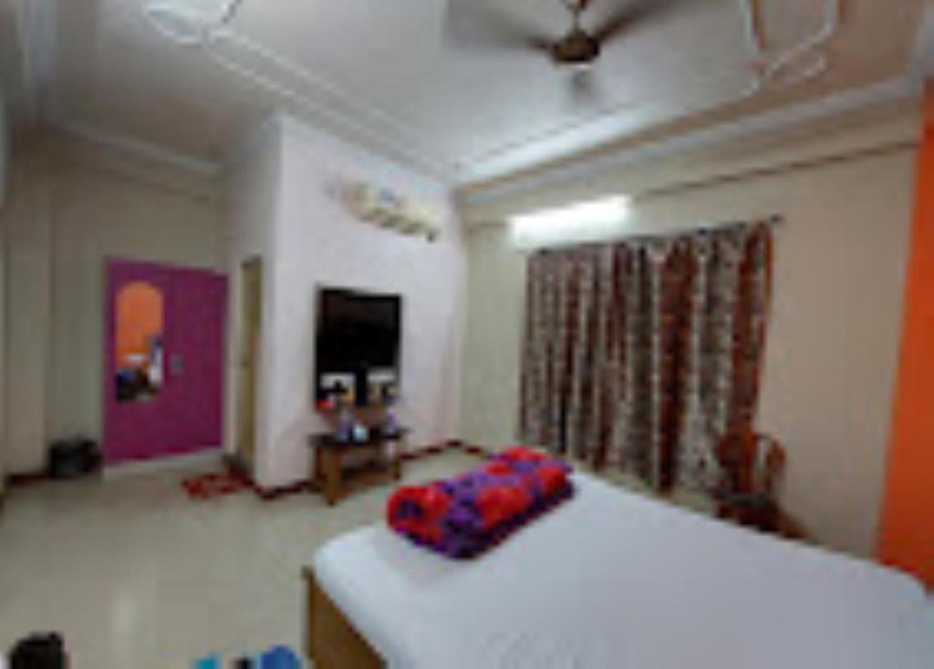 Un dormitorio con una cama con una almohada roja. en Hotel Royal Inn Tripura en Rahdakisorpur