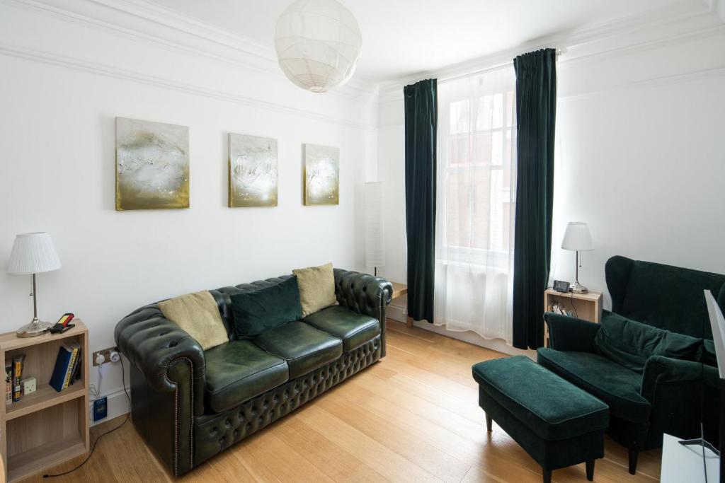 Elegant 1BR Apartment Near Central London في لندن: غرفة معيشة مع أريكة وكرسي