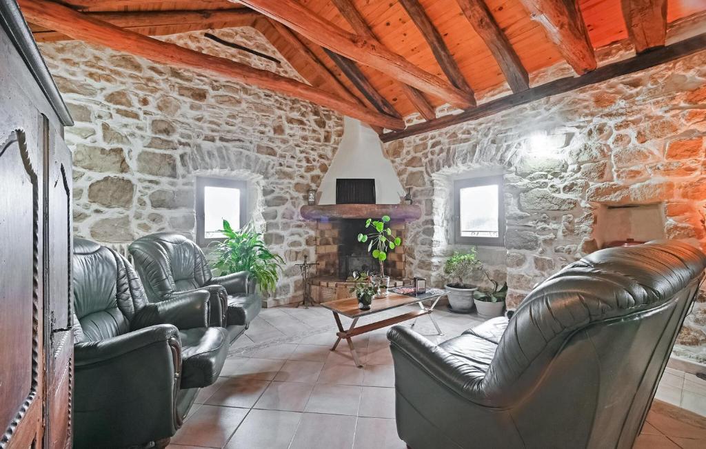 ein Wohnzimmer mit Ledersesseln und einer Steinmauer in der Unterkunft Awesome Apartment In Bordezac With Kitchen in Bordezac