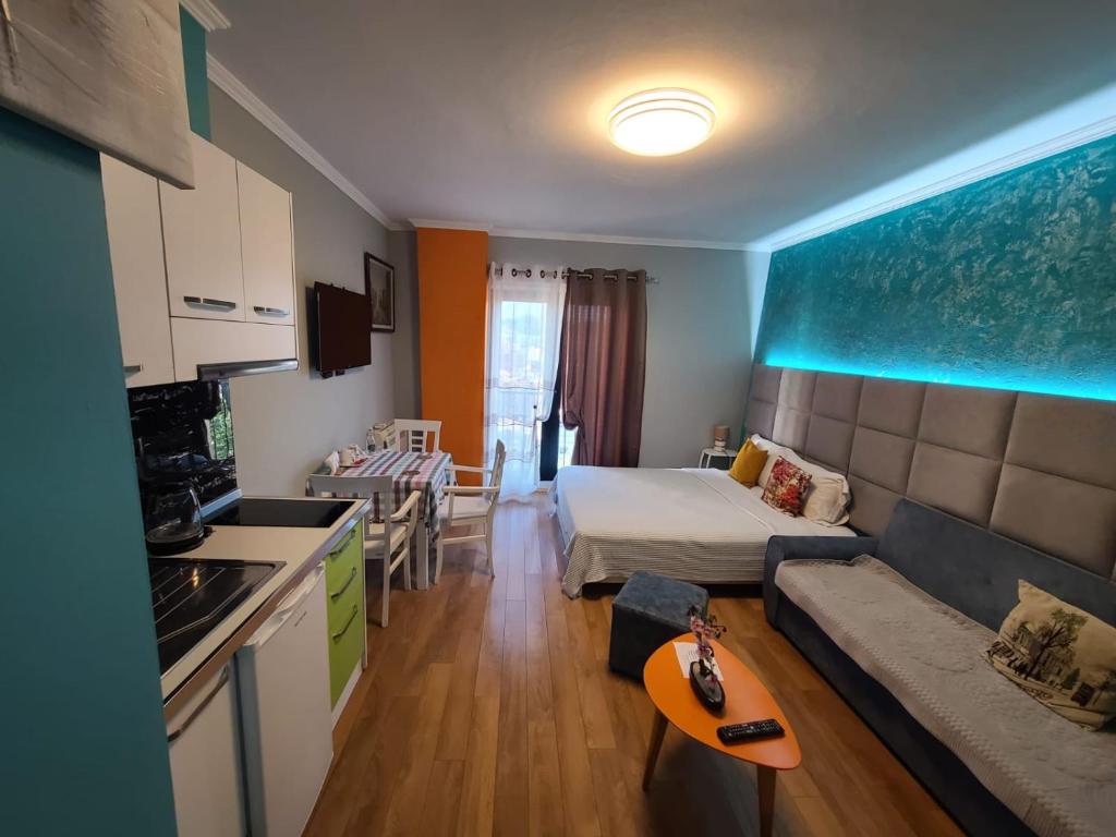 uma cozinha e uma sala de estar com uma cama e um sofá em My Apartments Tirane em Tirana