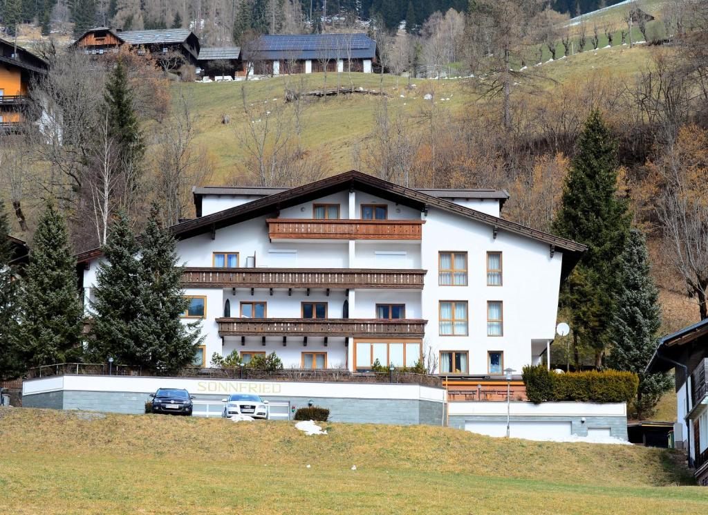 a large white building on a hill with trees at Forest Mountain Apartment in Bad Kleinkirchheim