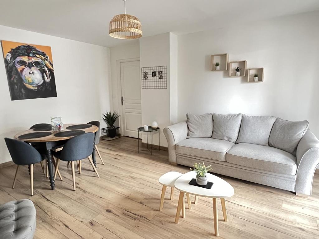 un salon avec un canapé et une table dans l'établissement Appartement 2 chambres Le Descartes, à Calais