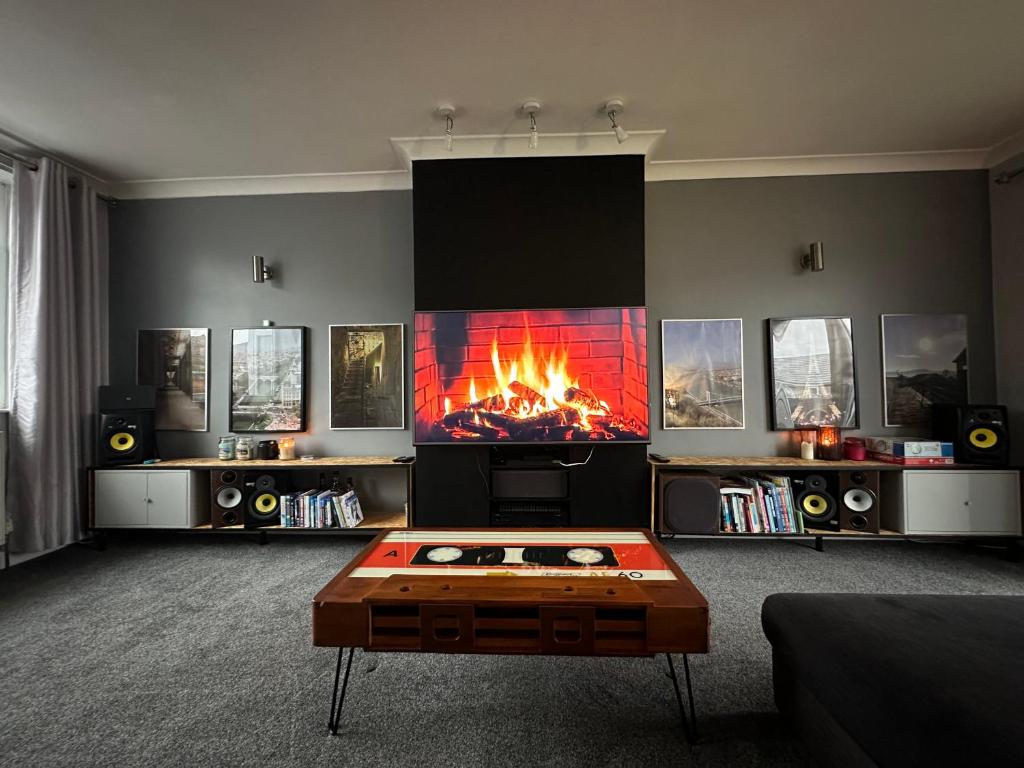 a living room with a fireplace and a table at Music lovers house in Morley