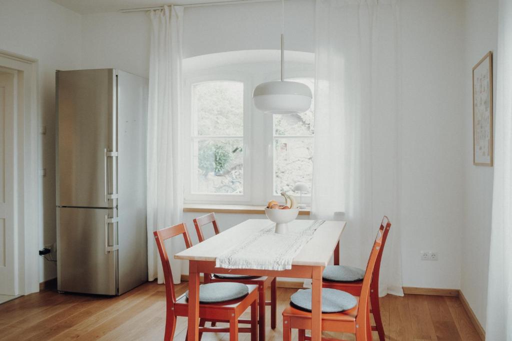 een keuken met een tafel met stoelen en een koelkast bij NEU! Historisches Bahnhofs Apartment in NW in Neustadt an der Weinstraße