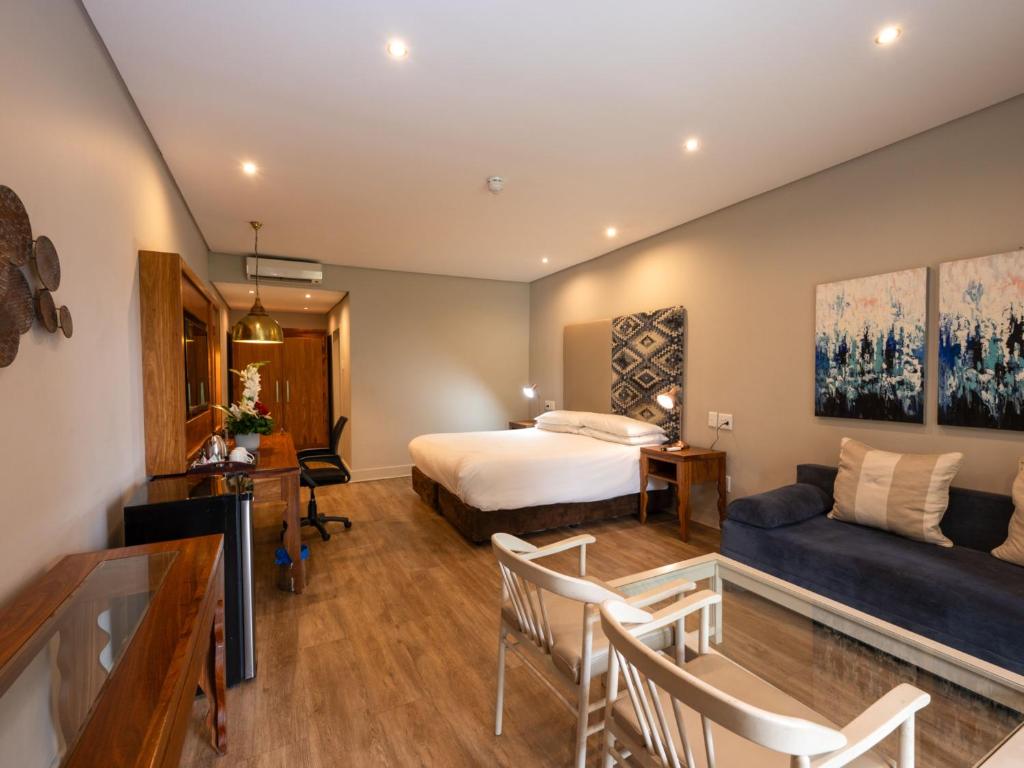 Habitación de hotel con cama y sofá en ANEW Resort Hunters Rest Rustenburg, en Rustenburg