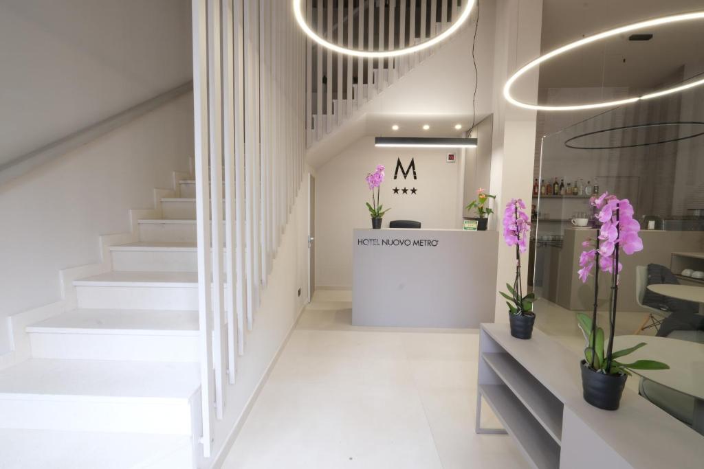 a lobby of a store with a staircase and flowers at Hotel Nuovo Metrò in Milan