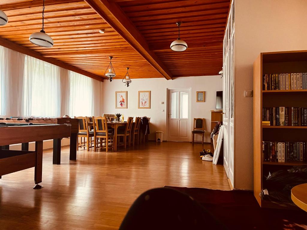 ein Zimmer mit einem Tisch, Stühlen und einem Bücherregal in der Unterkunft Favilla DELUXE Bogács in Bogács
