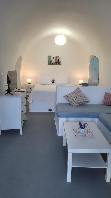 a room with two beds and a couch and a table at Kamaraki Grande Aroniadika in Kythira