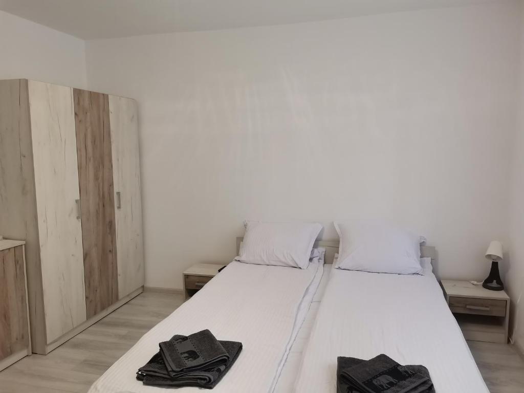 a bed with white sheets and black towels on it at Дива in Kŭrdzhali