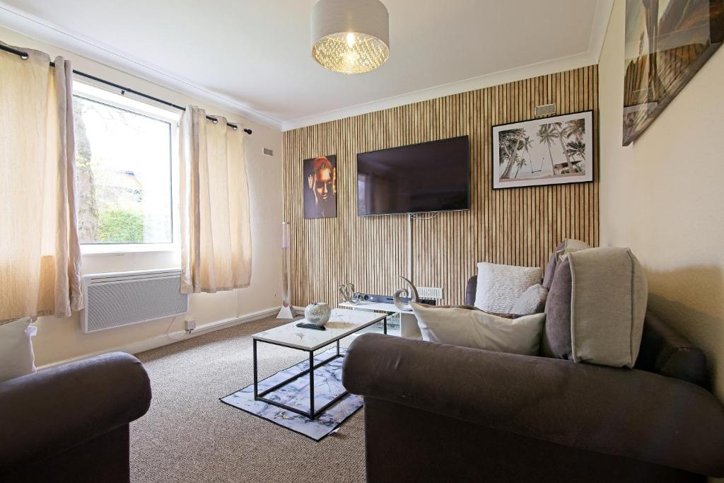 Stylish 1-Bed Apartment في مانشستر: غرفة معيشة مع أريكة وتلفزيون