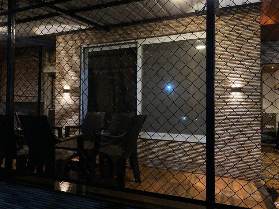 ein Zimmer mit einem Zaun mit einem Tisch und Stühlen in der Unterkunft Imagine star in Lonavla