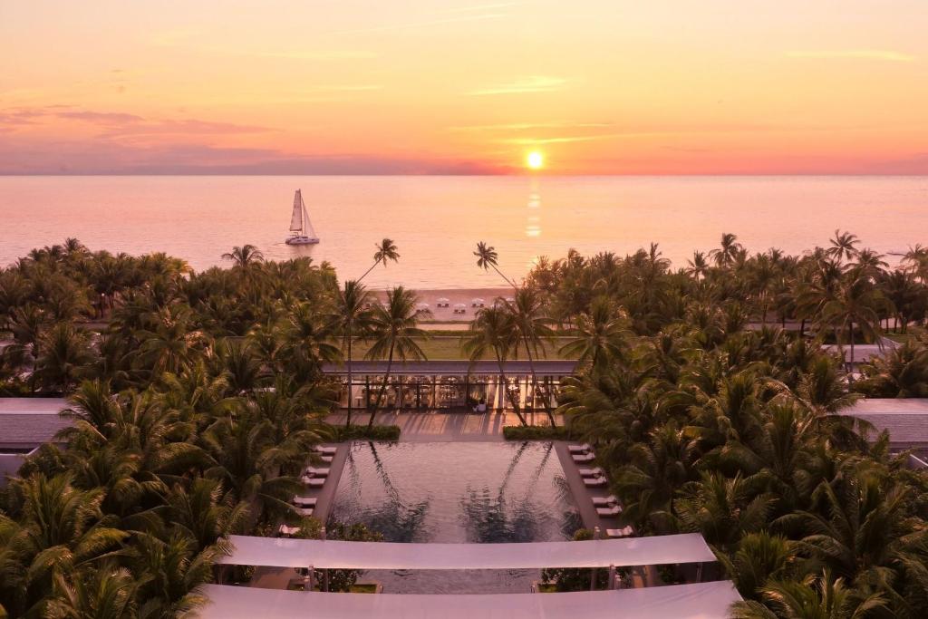 vista para uma piscina num resort ao pôr-do-sol em Regent Phu Quoc em Phu Quoc