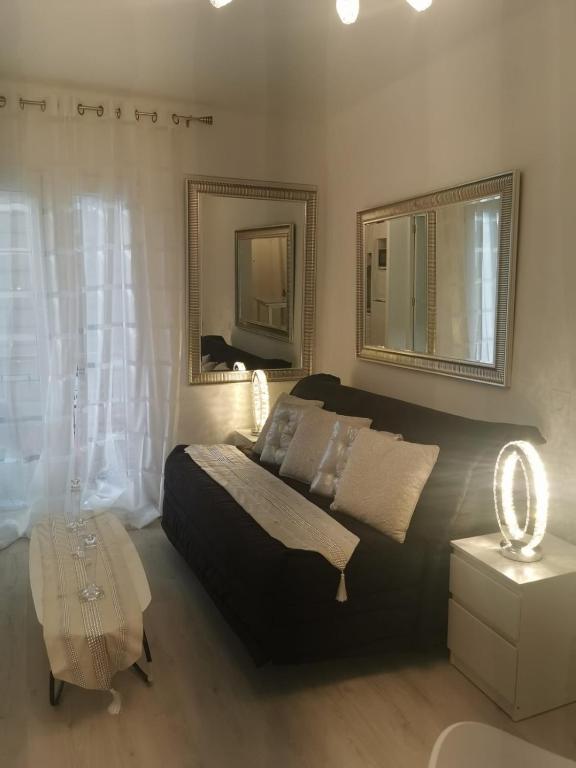 une chambre avec un lit, une table et un miroir dans l'établissement JIMMYS HOUSE 55, à Beausoleil