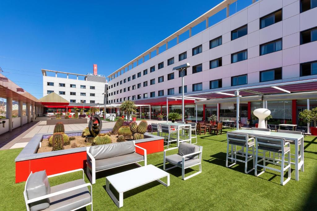 un patio con mesas y sillas y un edificio en Alexandre Hotel Frontair Congress en Sant Boi del Llobregat