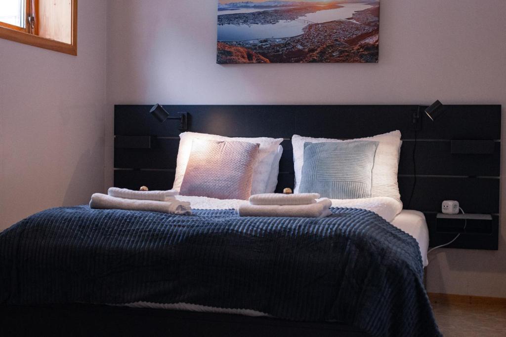1 dormitorio con 1 cama con cabecero negro y almohadas en Cozy and central among locals en Tromsø