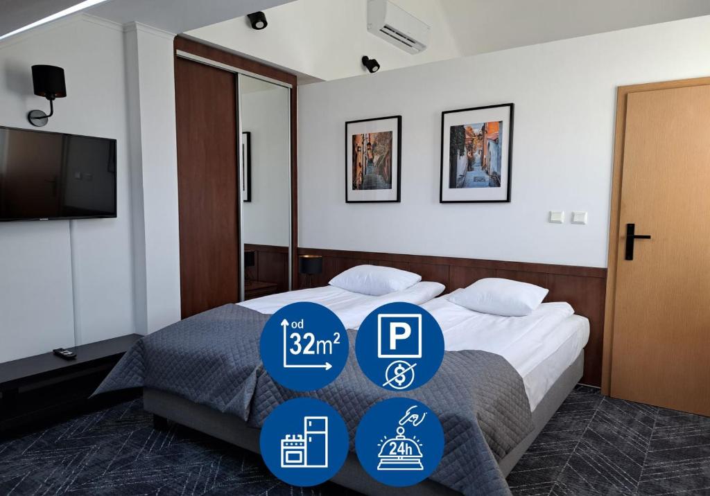 une chambre d'hôtel avec un lit avec trois étiquettes dans l'établissement Warsaw Apartments - Apartamenty Wilanów, à Varsovie