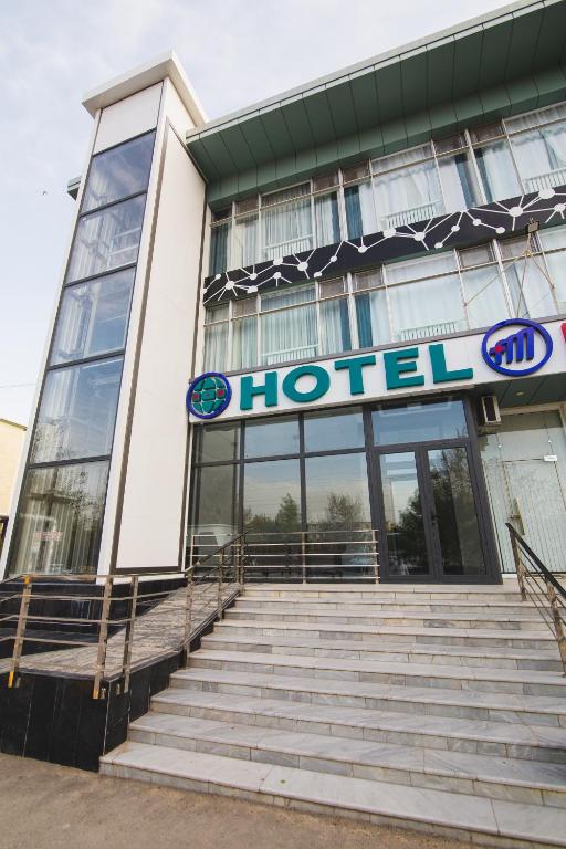 a hotel building with stairs in front of it at HOTEL MERCURI-MERIDIAN in Bukhara