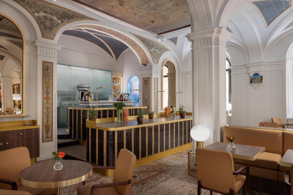 - un restaurant avec des tables, des chaises et des plafonds dans l'établissement Maison Roma Piazza di Spagna UNA Esperienze, à Rome