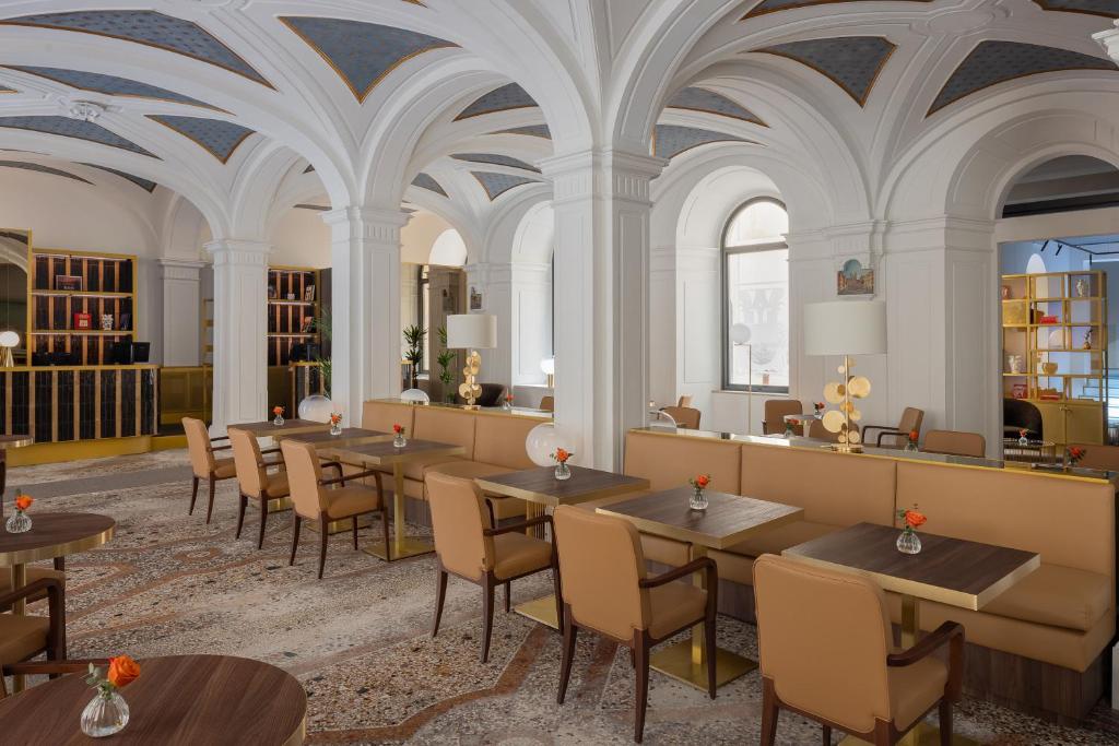 a restaurant with tables and chairs and ceilings at Maison Roma Piazza di Spagna UNA Esperienze in Rome