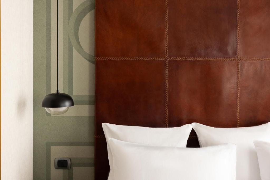 a bed with two white pillows and a wooden headboard at Maison Roma Piazza di Spagna UNA Esperienze in Rome