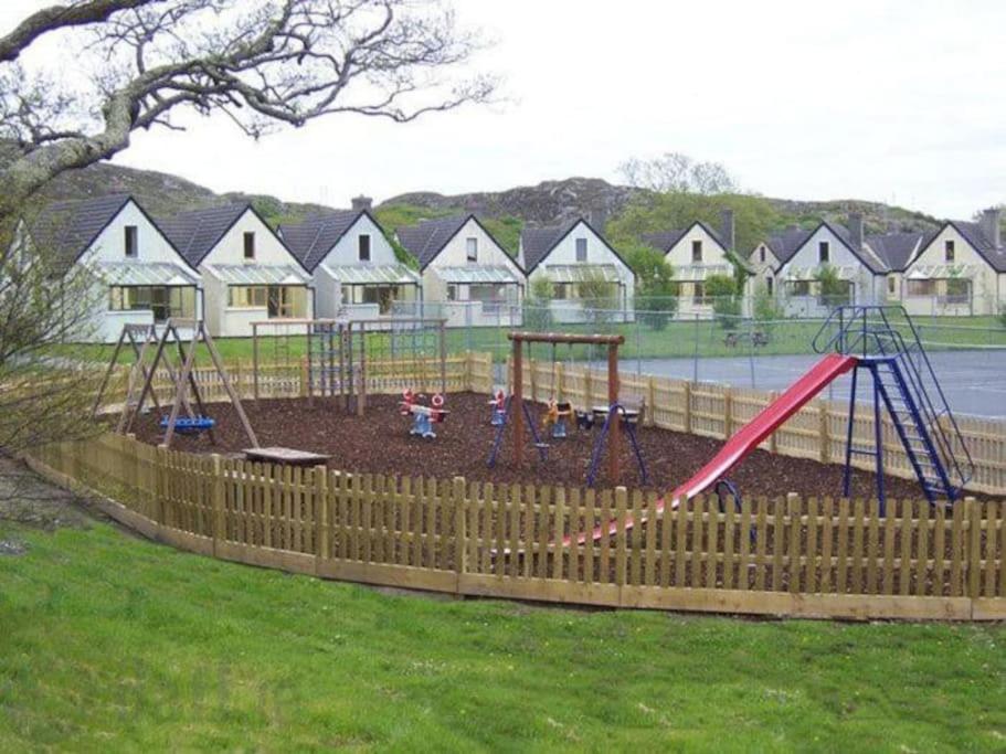 a playground with a swing set in a yard at Clifden Glen Cottage in Clifden