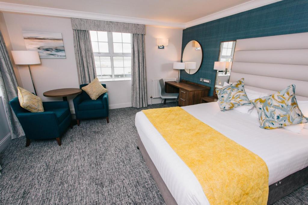a hotel room with a bed and a desk and a chair at Grand Hotel in Malahide