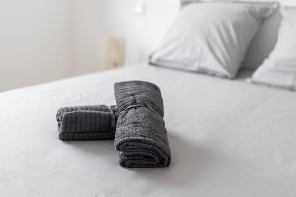a gray rolled up towel on a bed at T2 avec parking gratuit - proximité gare in Toulouse