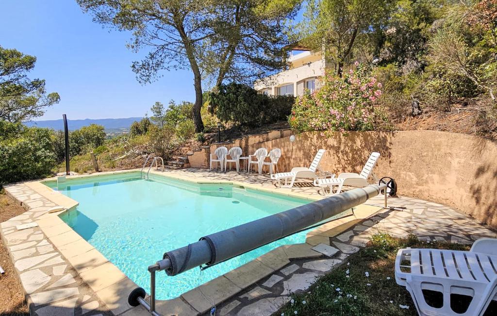 a large missile in a swimming pool with chairs at 3 Bedroom Gorgeous Home In Pierrerue in Pierrerue
