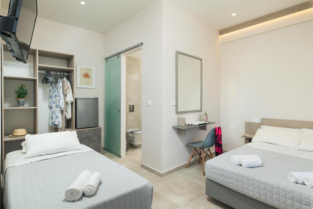 a hotel room with two beds and a bathroom at Stefanie Studios in Agia Marina Nea Kydonias