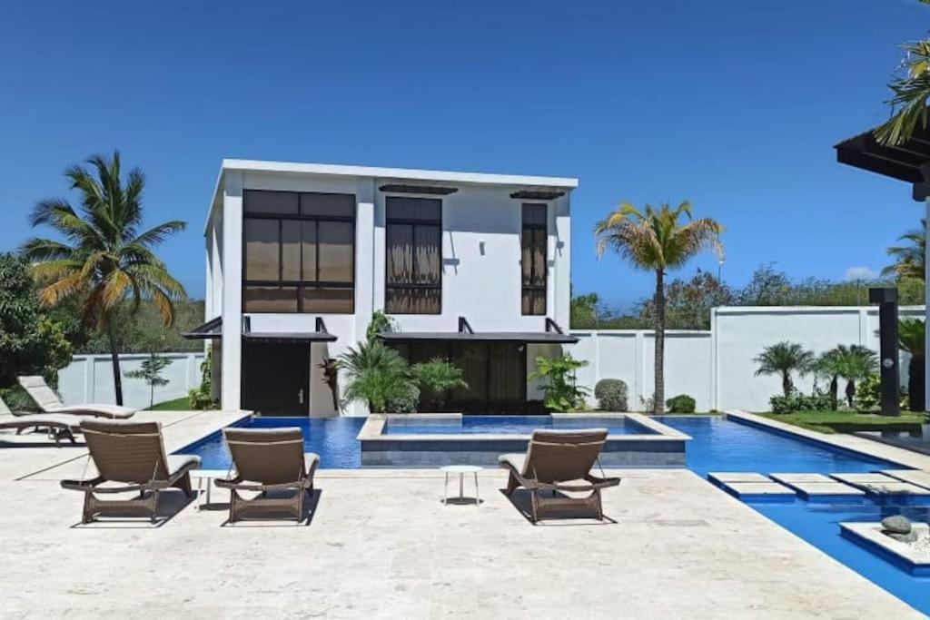 a villa with a swimming pool and chairs at Hacienda Ortiz: Luxury Space. in Matanzas