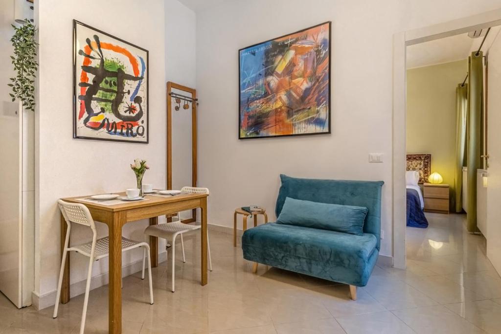 uma sala de estar com uma mesa e uma cadeira azul em Veneziacentopercento Zoto Apartment em Veneza