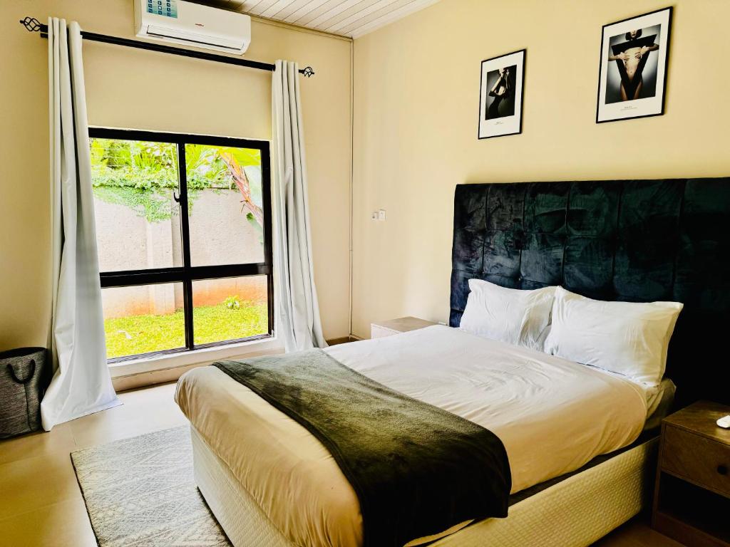 a bedroom with a bed and a large window at Kaya Apartments 2 in Lusaka