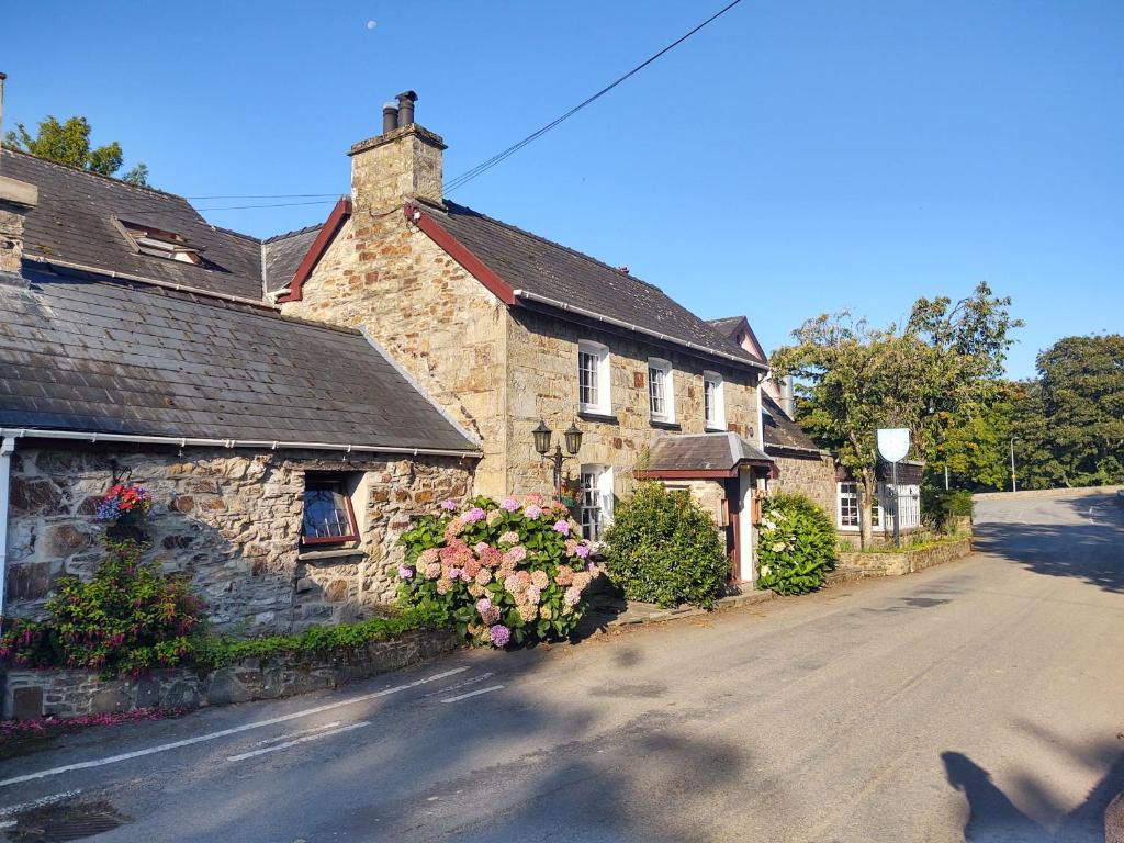 une maison en pierre avec des fleurs sur le côté d'une rue dans l'établissement Trewern Arms Hotel, à Newport