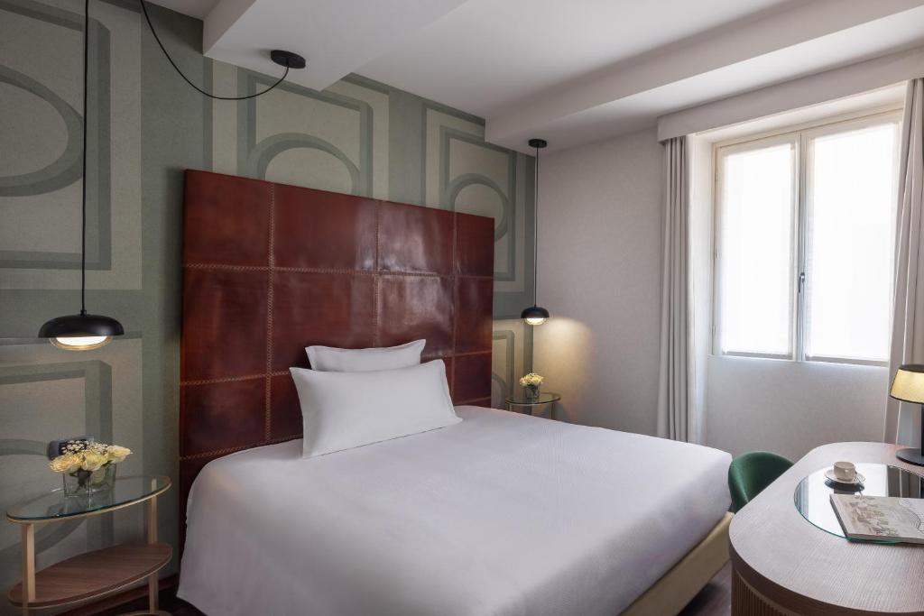 a bedroom with a large white bed and a table at Maison Roma Piazza di Spagna UNA Esperienze in Rome