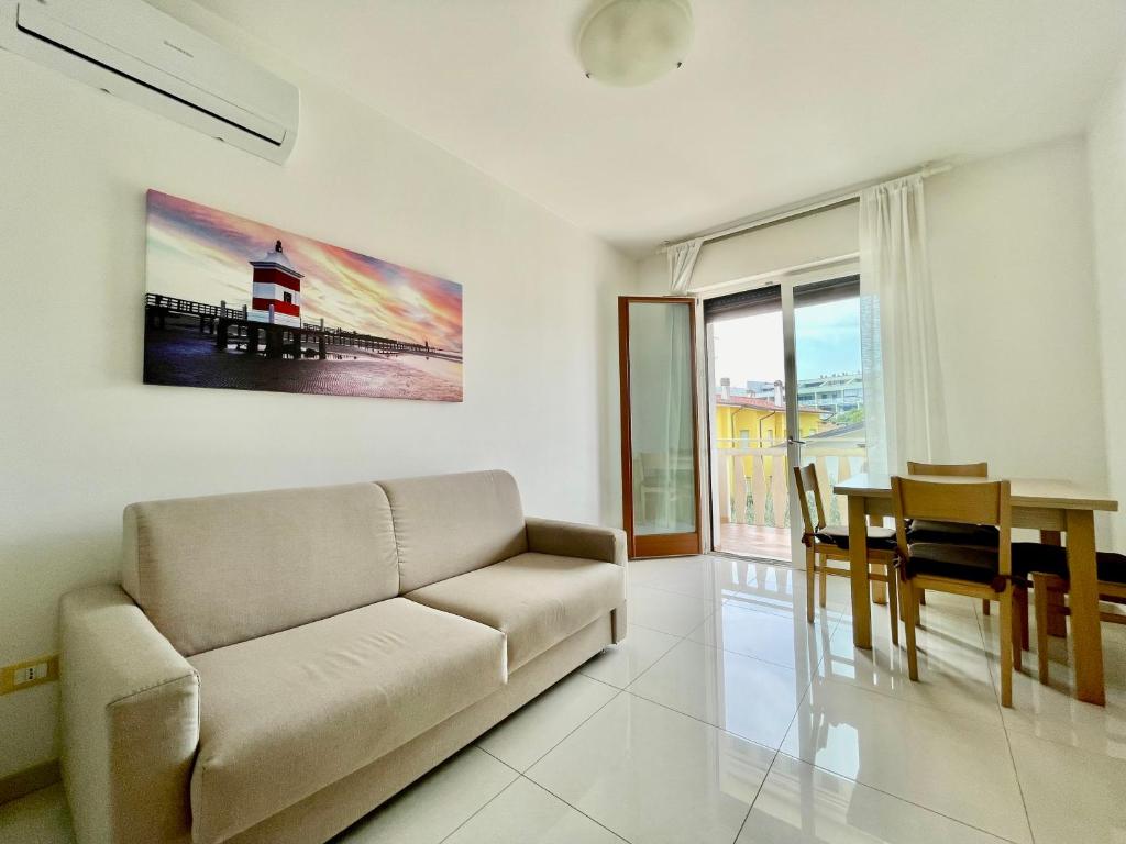 uma sala de estar com um sofá e uma mesa em Appartamento Al Faro I TerraceRelax&Parking em Lignano Sabbiadoro