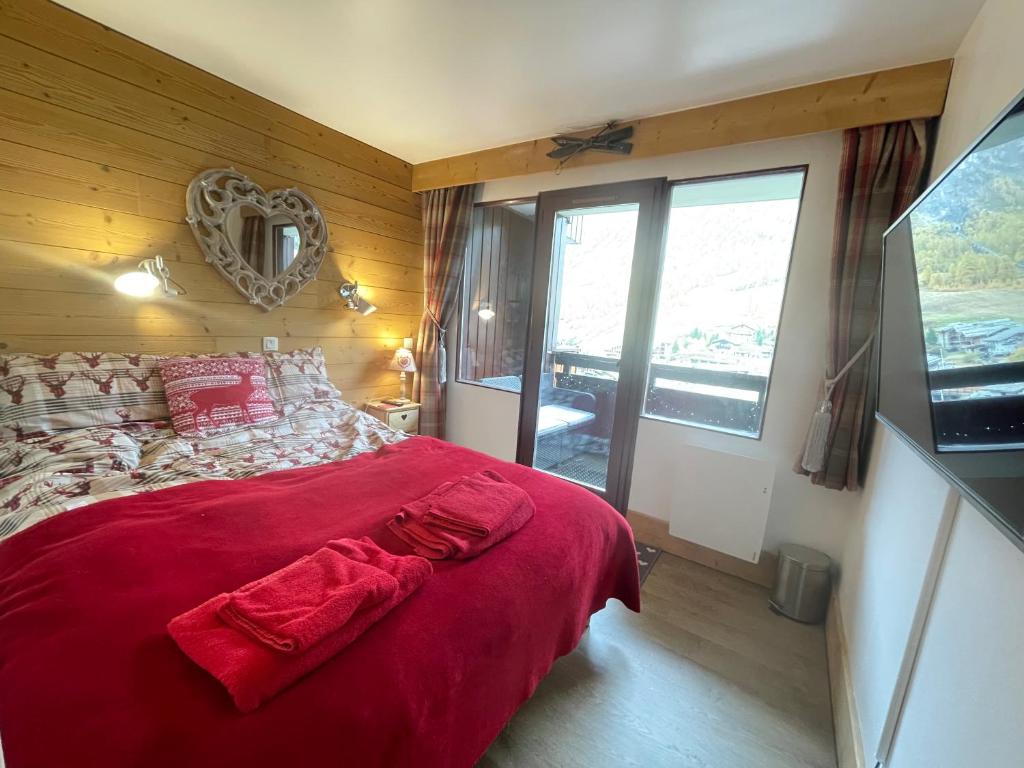 a bedroom with a bed with a red blanket at Les Balcons de Bellevarde in Val-d'Isère