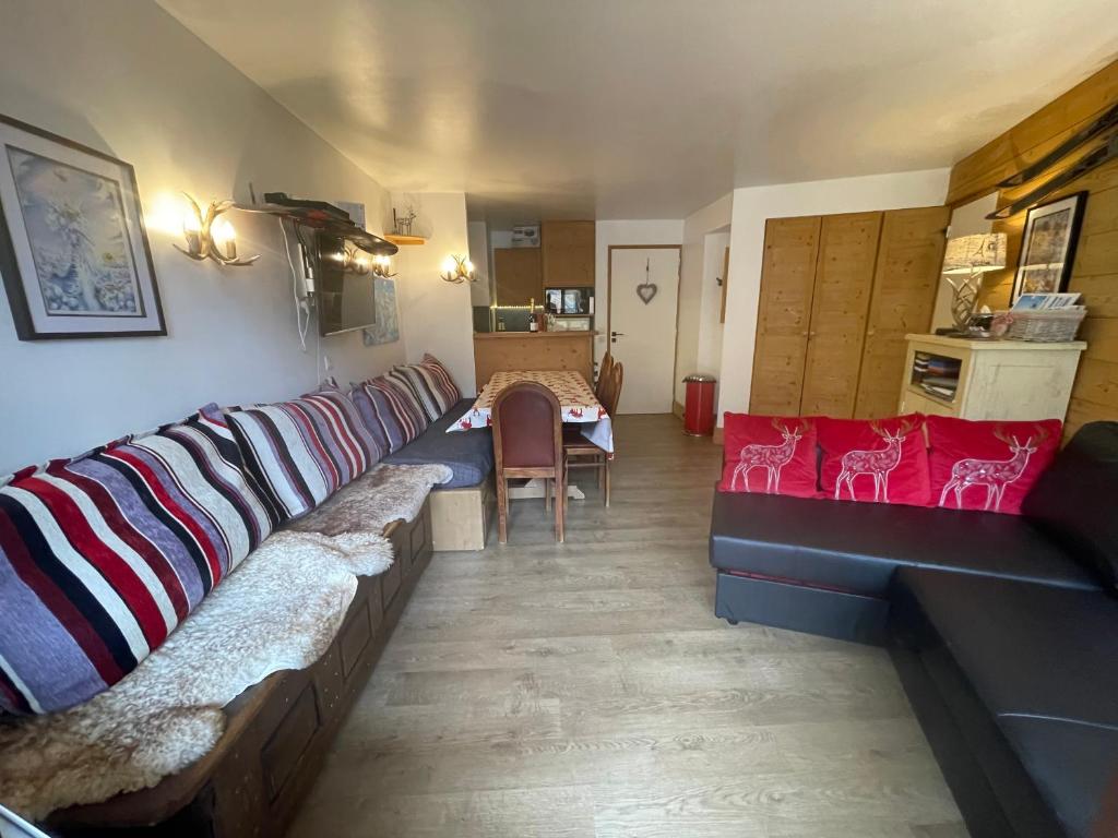a living room with a long couch and a table at Les Balcons de Bellevarde in Val-d'Isère