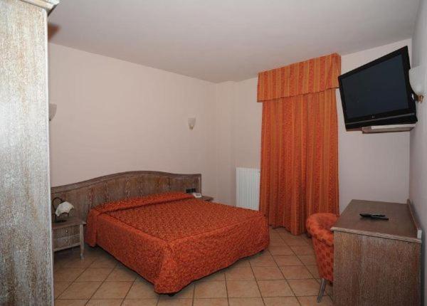 1 dormitorio con 1 cama y TV de pantalla plana en Locanda Agnello en Taino