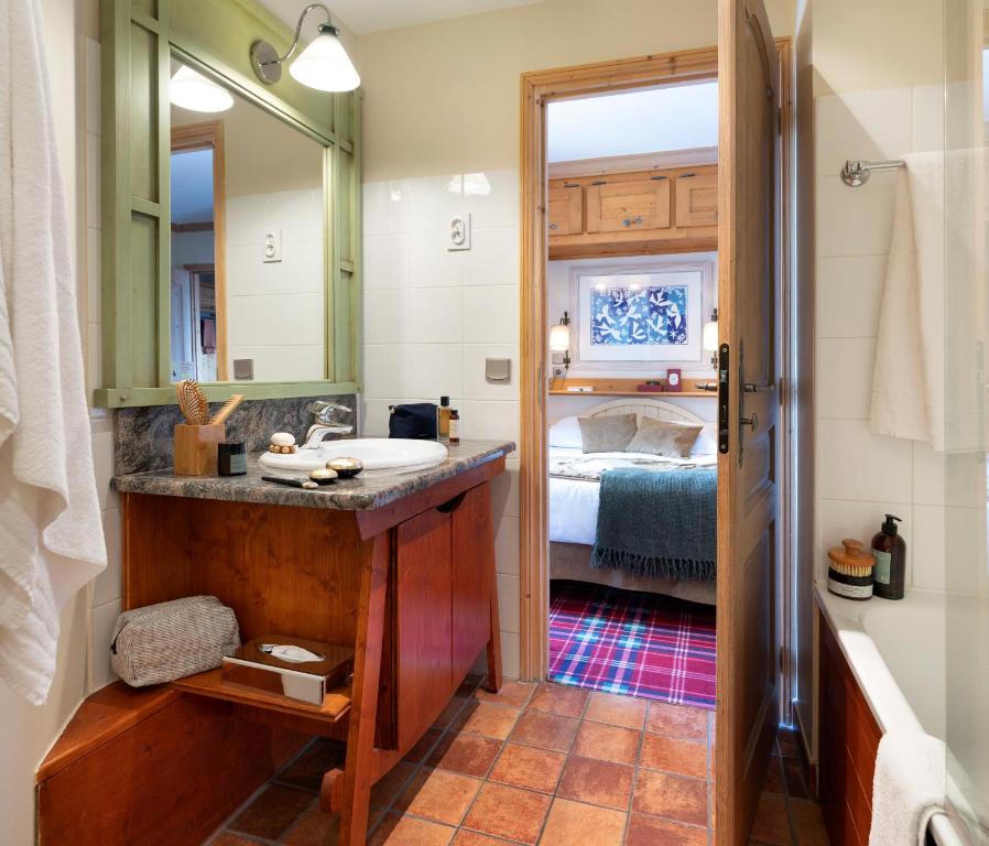 a bathroom with a sink and a mirror and a bed at Résidence Pierre & Vacances Premium Arc 1950 Le Village in Arc 1950