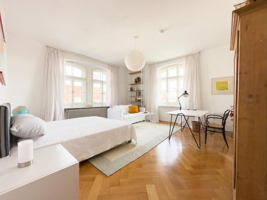 ein weißes Schlafzimmer mit einem Bett und einem Schreibtisch in der Unterkunft Lehnervilla in Parsberg