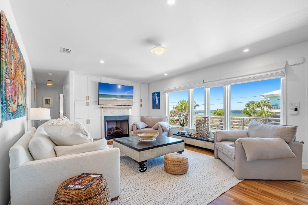 a living room with white furniture and a view of the ocean at Sav's Beach Pad in Pensacola Beach