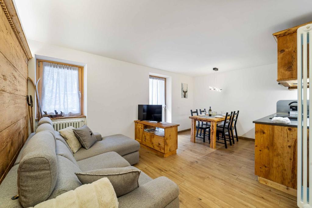 ein Wohnzimmer mit einem Sofa und einem Tisch in der Unterkunft Casa Graziosa in Campodolcino