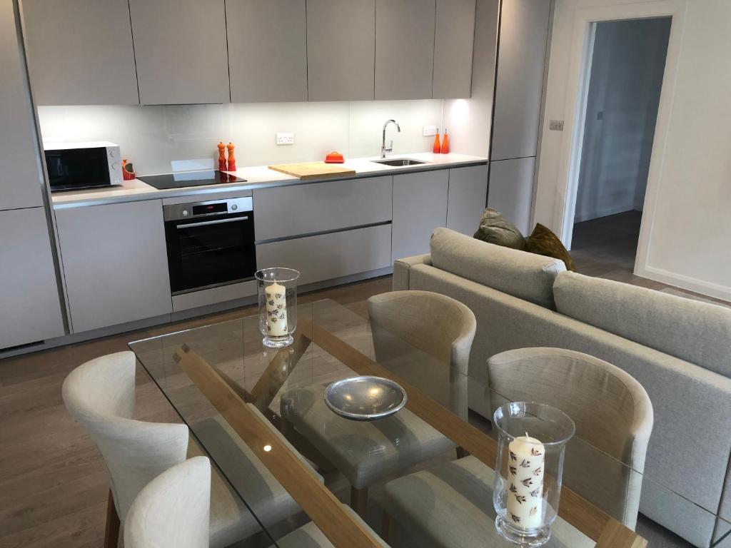 Hotel New! Fantastic 1 Bedroom Flat SW6 near Central London, a kitchen and a living room with a glass table at New! Fantastic 1 Bedroom Flat SW6 near Central London in London