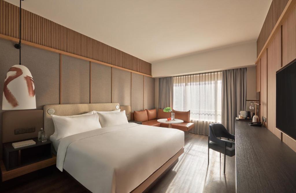 ein Hotelzimmer mit einem großen Bett und einem TV in der Unterkunft Amara Singapore - Newly Renovated in Singapur