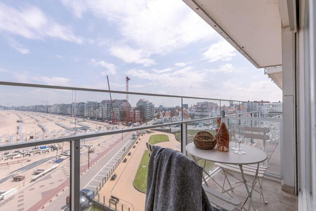 een balkon met een tafel en uitzicht op het strand bij Stunning studio with sea-view and terrace in Knokke-Heist