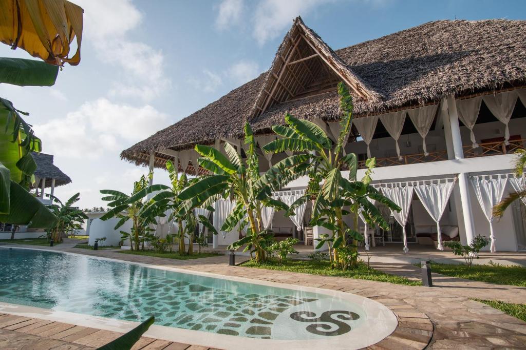 a resort with a swimming pool in front of a building at Mwezi - Maisha Resort in Watamu