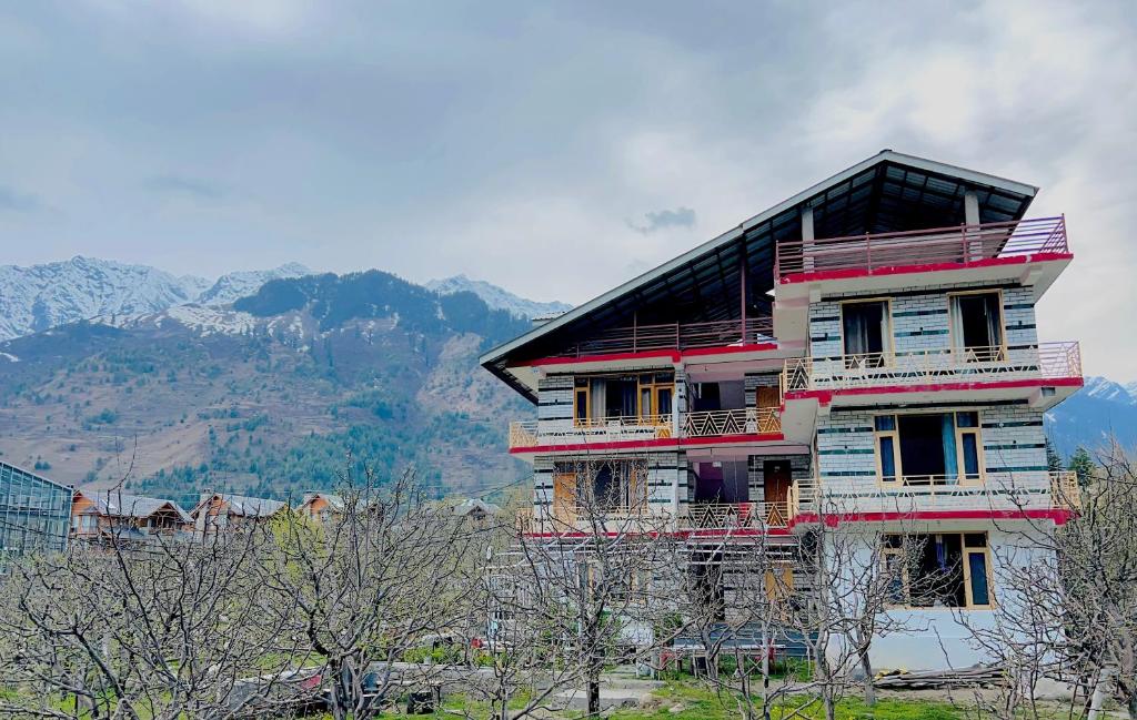 ein Haus auf einem Hügel mit Bergen im Hintergrund in der Unterkunft Burwa Breeze By Winsum Stays in Palchān