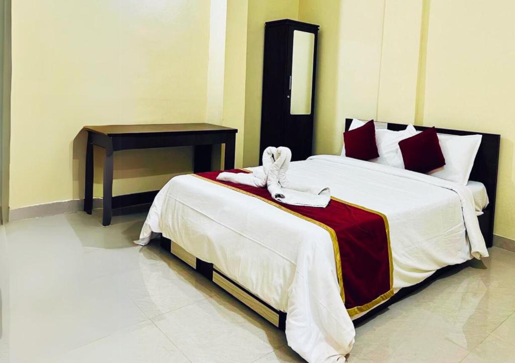 a hotel room with two beds and a table at Rivera Holiday Home in Vythiri